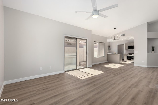 unfurnished living room featuring ceiling fan with notable chandelier, wood-type flooring, and lofted ceiling