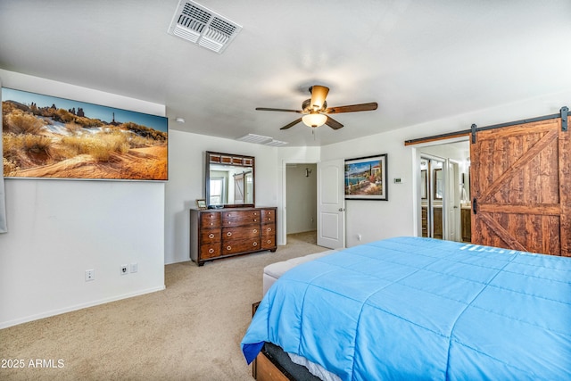 carpeted bedroom featuring a barn door and ceiling fan