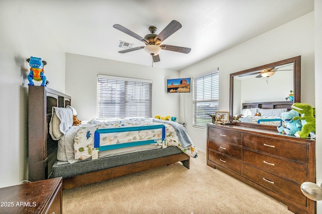 carpeted bedroom with ceiling fan and multiple windows