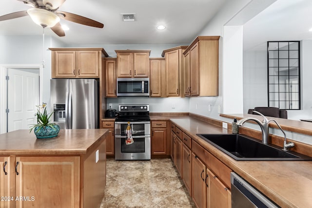 kitchen with stainless steel appliances, ceiling fan, sink, a center island, and light tile patterned flooring