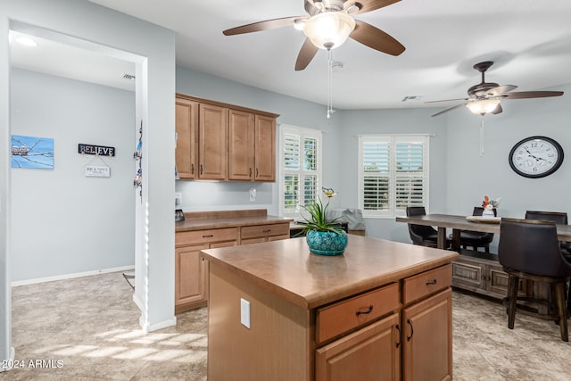 kitchen featuring light tile patterned floors, a kitchen island, and ceiling fan