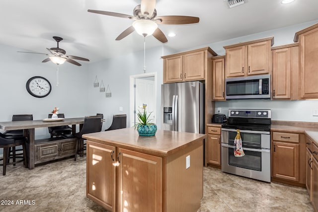 kitchen with ceiling fan, a center island, and appliances with stainless steel finishes