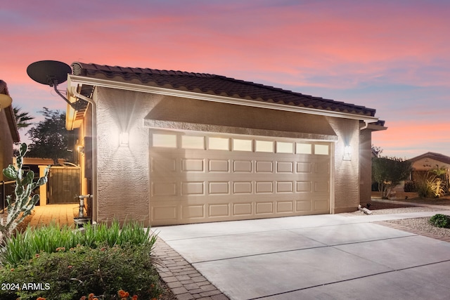 view of garage at dusk