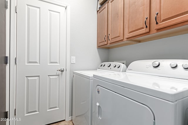 laundry room featuring separate washer and dryer and cabinets