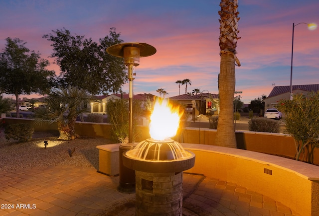 patio terrace at dusk featuring a fire pit