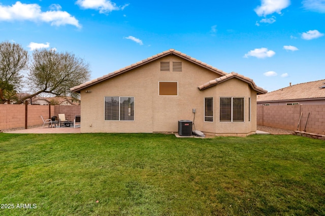 back of house with cooling unit, a patio area, and a lawn