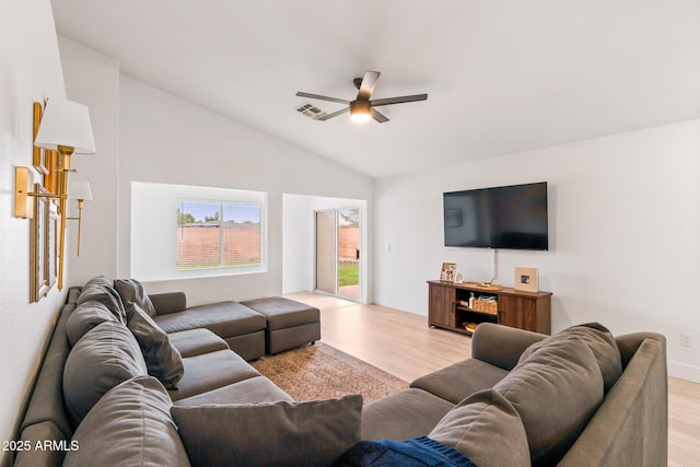 living room featuring ceiling fan, vaulted ceiling, and light wood-type flooring