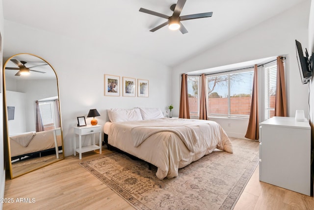 bedroom with ceiling fan, lofted ceiling, and light hardwood / wood-style floors