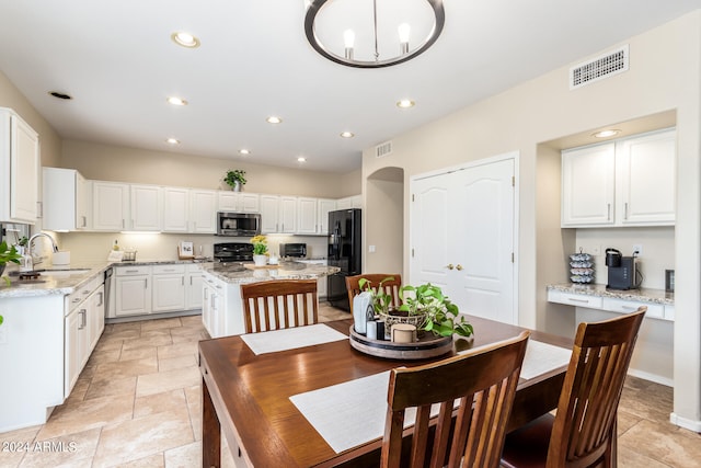 dining space with an inviting chandelier and sink