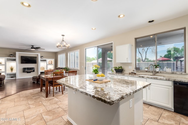 kitchen featuring white cabinets, dishwasher, light wood-type flooring, ceiling fan with notable chandelier, and sink