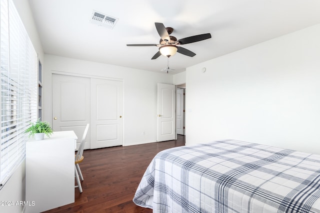 bedroom featuring dark wood-type flooring, ceiling fan, and a closet