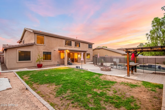 back house at dusk featuring a patio, a fenced in pool, a pergola, a yard, and an outdoor fire pit