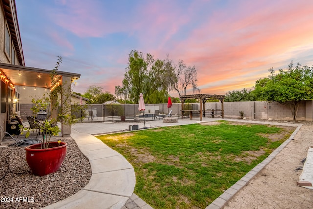 yard at dusk featuring a patio and a pergola