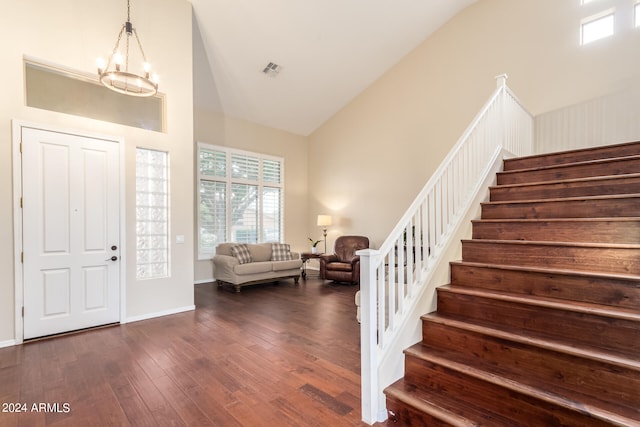 entryway featuring dark hardwood / wood-style floors, high vaulted ceiling, and an inviting chandelier