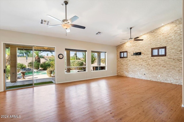 unfurnished living room with hardwood / wood-style flooring, high vaulted ceiling, and ceiling fan