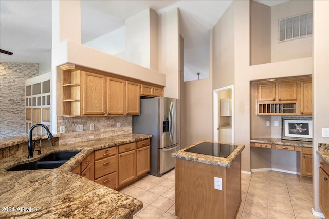 kitchen featuring a kitchen island, stainless steel fridge with ice dispenser, sink, and light tile patterned floors