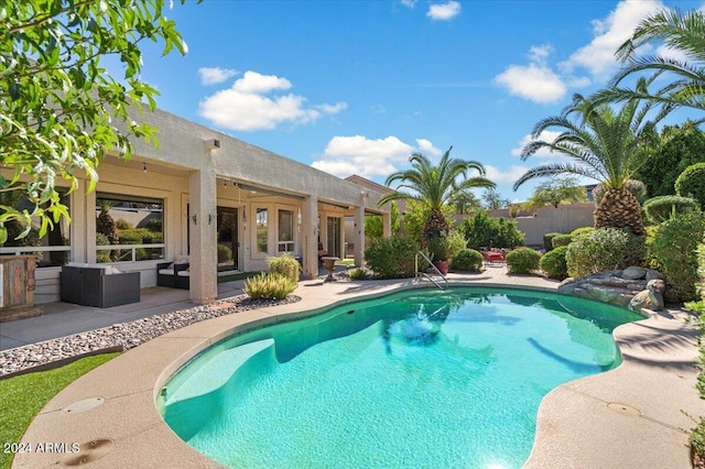 view of pool with outdoor lounge area, a patio, and french doors