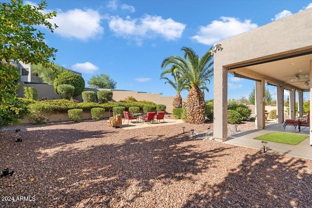 view of yard with ceiling fan and a patio