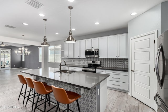 7824 S 33rd Ln, Laveen, AZ 85339 - kitchen featuring stainless steel appliances, a sink, decorative backsplash, a breakfast bar, and recessed lighting
