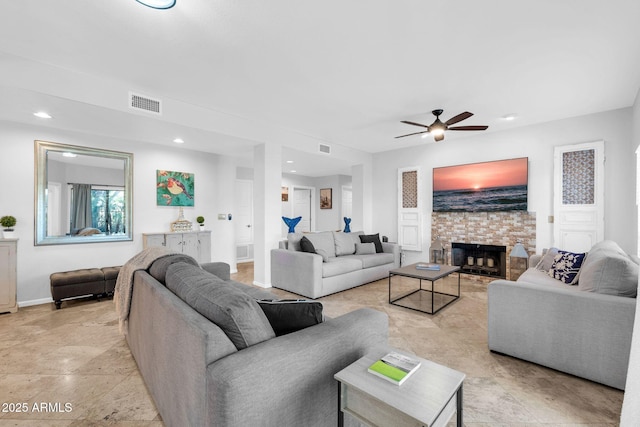 living room with a fireplace and ceiling fan