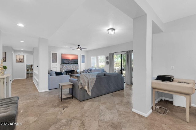 living room with a fireplace and ceiling fan