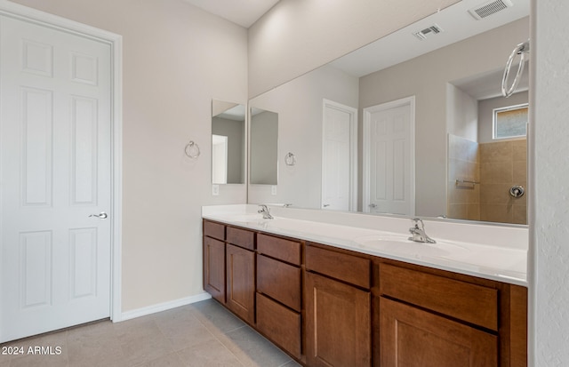 bathroom featuring vanity, tile patterned floors, and tiled shower