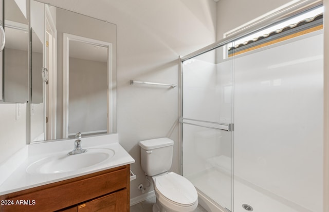 bathroom with vanity, toilet, and a shower with shower door