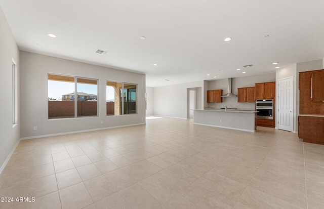 unfurnished living room with sink and light tile patterned floors