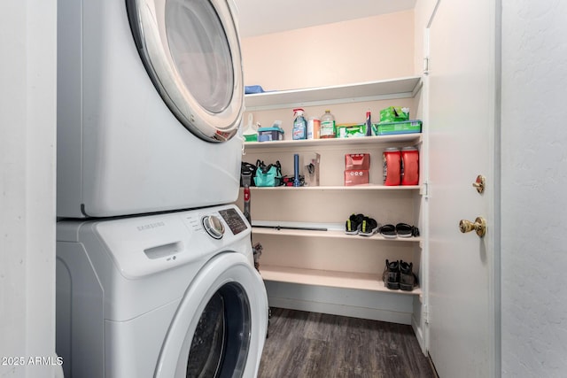 washroom with stacked washer / drying machine and dark wood-type flooring