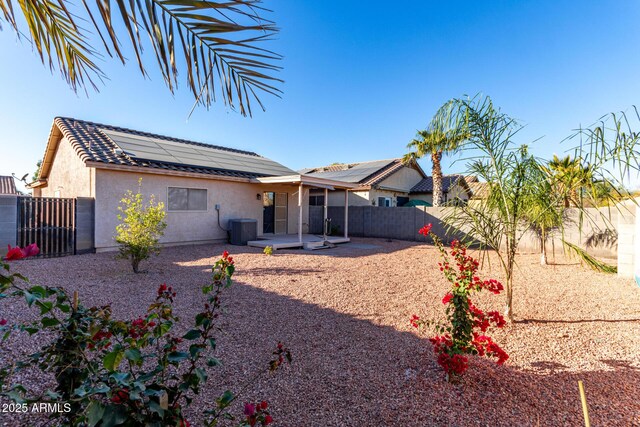 rear view of house featuring solar panels, a patio, and central air condition unit