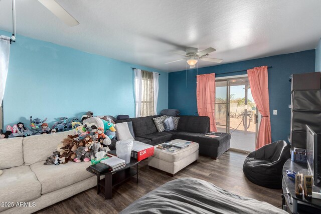 living room featuring a healthy amount of sunlight, ceiling fan, and dark wood-type flooring