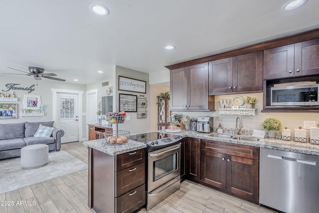 kitchen with a sink, stainless steel appliances, dark brown cabinetry, and wood tiled floor