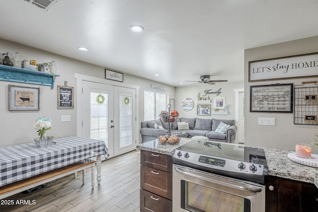 kitchen featuring dark brown cabinets, french doors, stainless steel range with electric stovetop, and light wood-style flooring