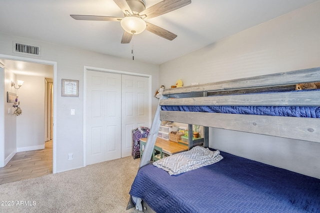 carpeted bedroom featuring a closet, visible vents, and ceiling fan