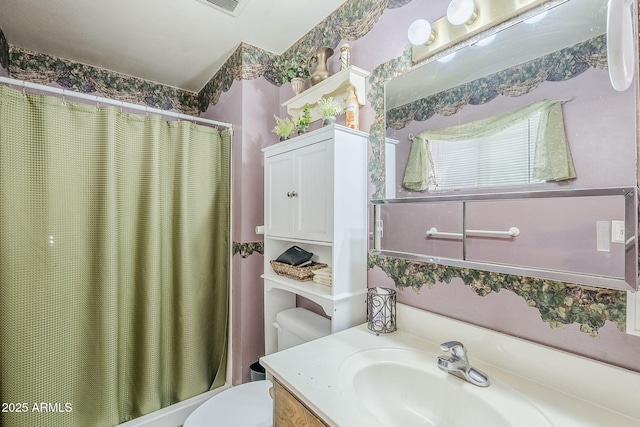 full bath featuring toilet, vanity, and shower / tub combo