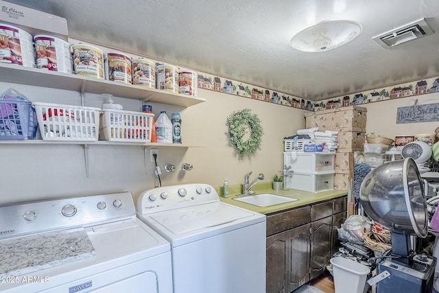 laundry area featuring cabinet space, separate washer and dryer, visible vents, and a sink