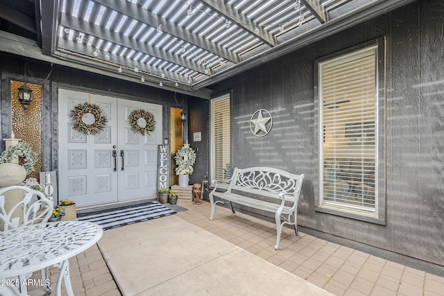 view of exterior entry with a pergola