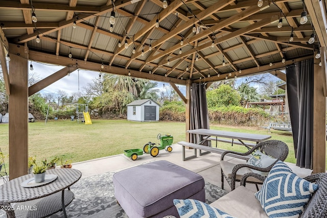 view of patio / terrace featuring a gazebo, an outbuilding, a playground, and a storage unit