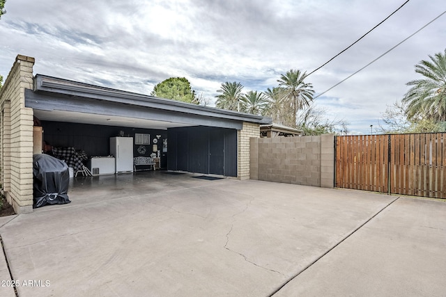 garage with freestanding refrigerator and fence