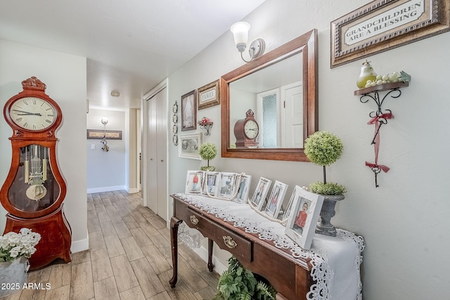 corridor with baseboards and wood finish floors