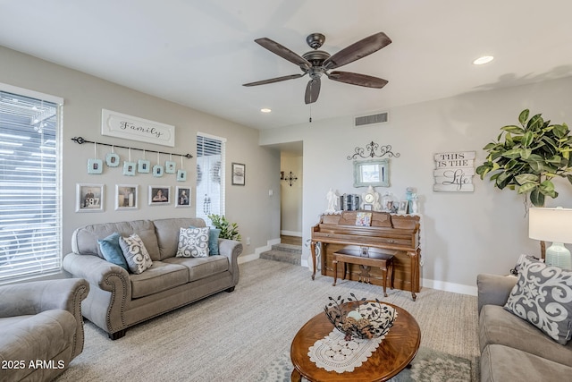 carpeted living room featuring visible vents, a healthy amount of sunlight, and baseboards