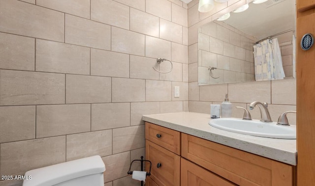 bathroom with tile walls, a shower with shower curtain, vanity, tasteful backsplash, and toilet