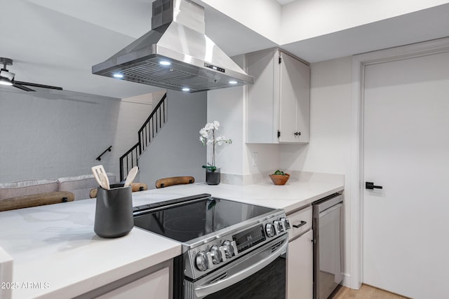 kitchen with extractor fan, ceiling fan, light wood-type flooring, white cabinets, and stainless steel appliances