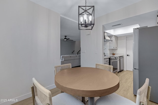 dining space with visible vents, baseboards, light wood-type flooring, and ceiling fan