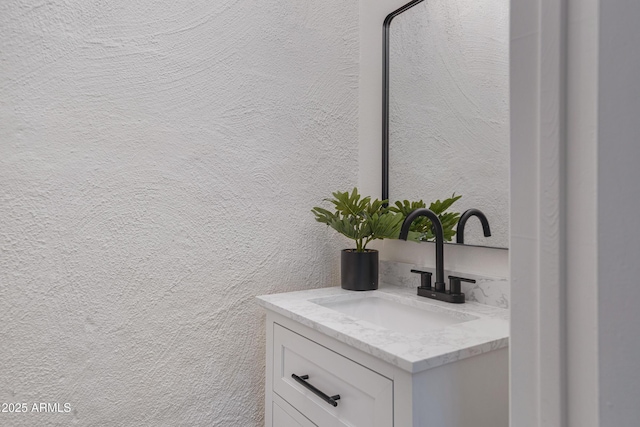 bathroom featuring vanity and a textured wall