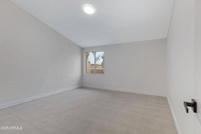 unfurnished room featuring light colored carpet and baseboards