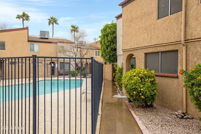 view of swimming pool with a fenced in pool, cooling unit, and fence