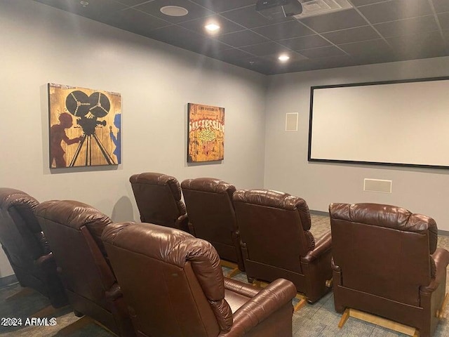 carpeted home theater room with a paneled ceiling