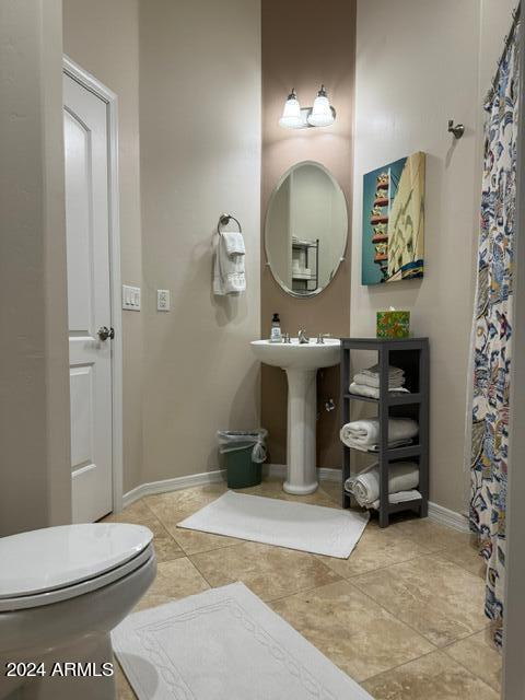 bathroom featuring tile floors and toilet