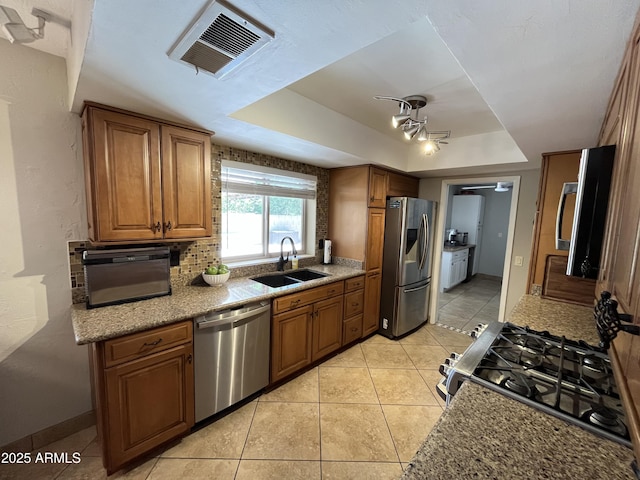 8355 E Via De Encanto, Scottsdale, AZ 85258 - kitchen with stainless steel appliances, a raised ceiling, brown cabinets, ceiling fan, and light tile patterned floors